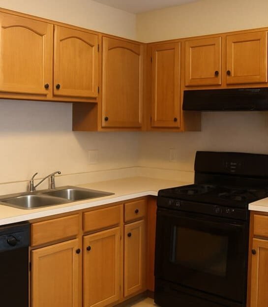 Traditional kitchen with light wood cabinets and black appliances